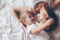 Mother and child laying on bed